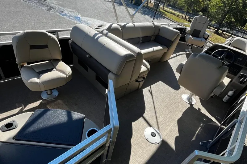 Slide: The Image of 2025 Sun Tracker SportFish 20 DLX interior with beige seating and steering console. - 7
