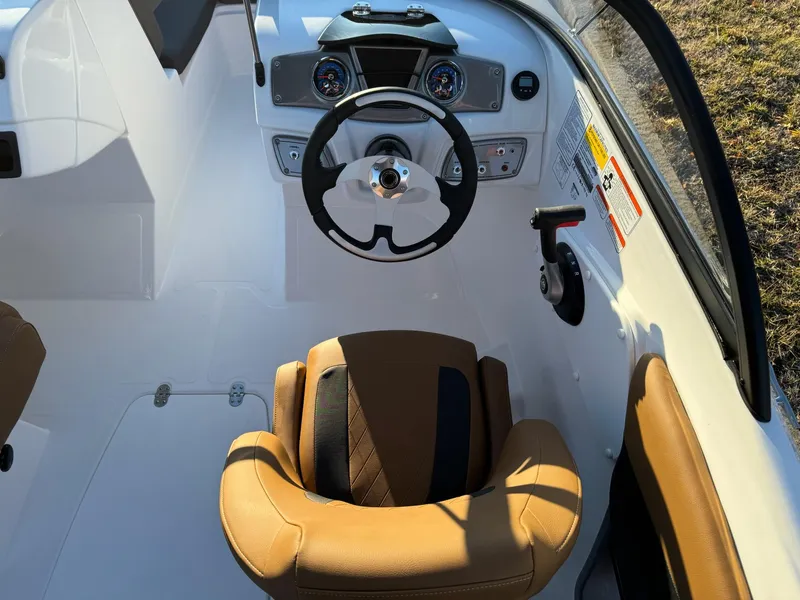 Slide: The Image of 2025 Tahoe 200 S boat cockpit with tan seating and modern steering wheel. - 11