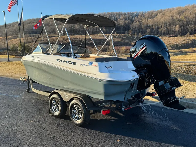 Slide: The Image of 2025 Tahoe 200 S boat on trailer with Mercury outboard motor, parked outdoors. - 2