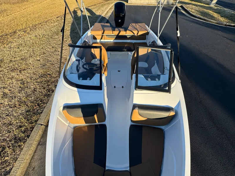 Slide: The Image of 2025 Tahoe 200 S boat with open cockpit and seating, parked on a sunny day. - 9