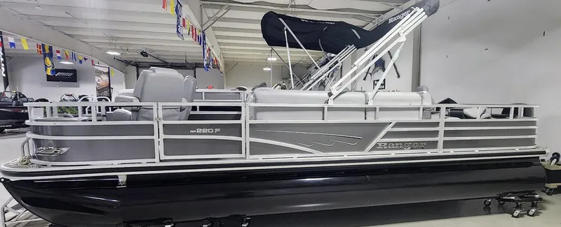 Slide: The Image of 2025 Ranger Reata 220F pontoon boat in showroom, featuring sleek design and modern amenities. - 1