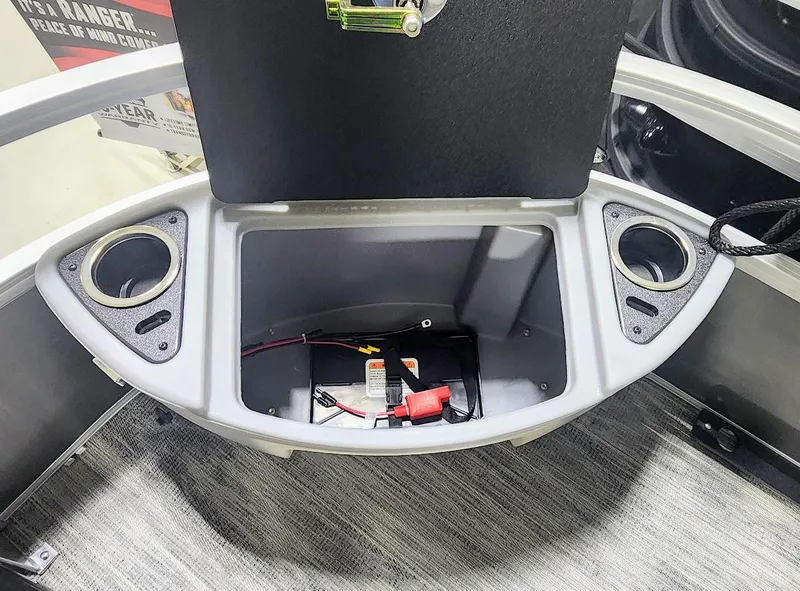 Slide: The Image of 2025 Ranger Reata 220F boat storage compartment with cup holders and battery. - 4