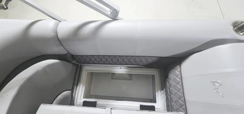 Slide: The Image of 2025 Ranger Reata 220F interior with quilted gray upholstery and storage compartment. - 9
