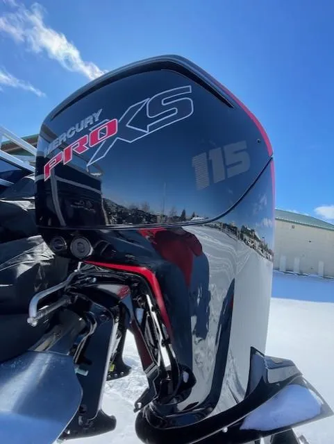 Slide: The Image of Mercury Pro XS 115 outboard motor on 2025 Sun Tracker Fishin' Barge 20 DLX, under clear blue sky. - 2