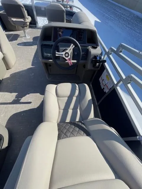 Slide: The Image of 2025 Sun Tracker Fishin' Barge 20 DLX interior with steering wheel and seating. - 4