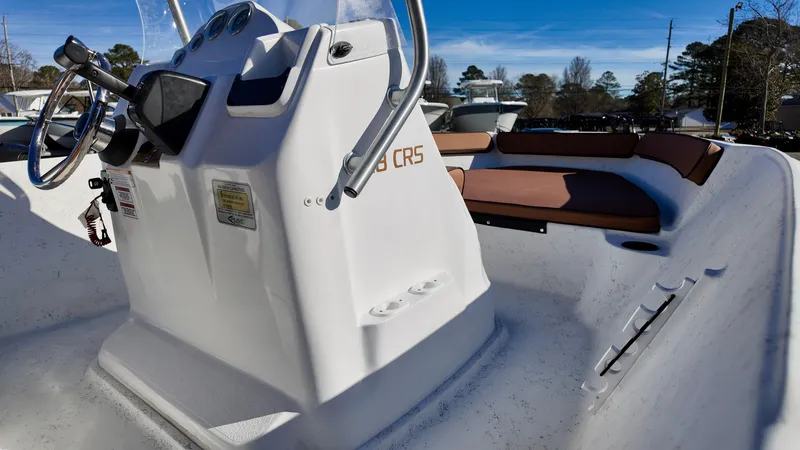 Slide: The Image of 2025 ALK2 Powerboats 18 CRS, white console, brown seating, outdoor setting. - 4