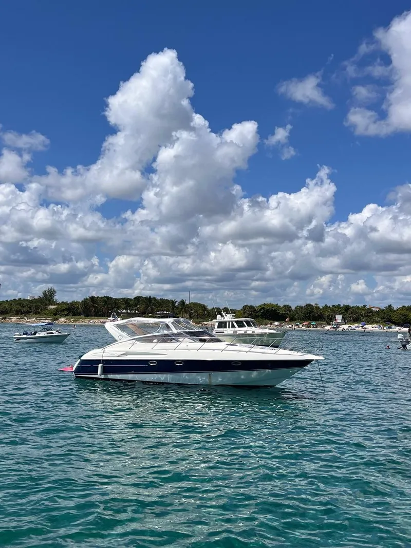 Slide: The Image of 2003 Cranchi Endurance 39 yacht on clear blue water under a cloudy sky. - 2