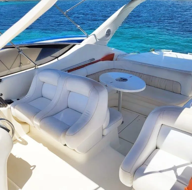 Slide: The Image of 2003 Cranchi Endurance 39 yacht interior with white seating and ocean view. - 4