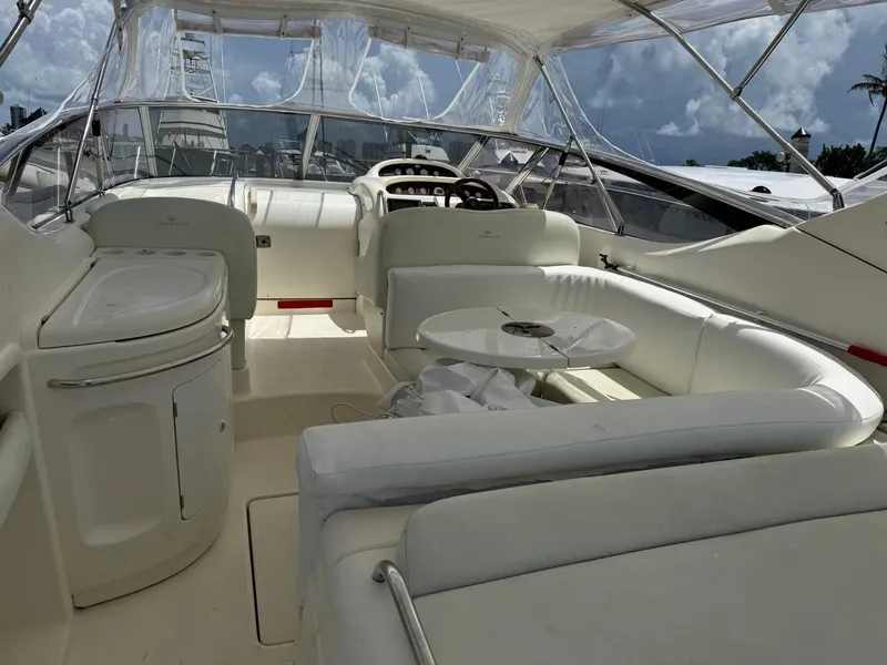 Slide: The Image of 2003 Cranchi Endurance 39 yacht interior with white seating and helm, under a clear canopy. - 5