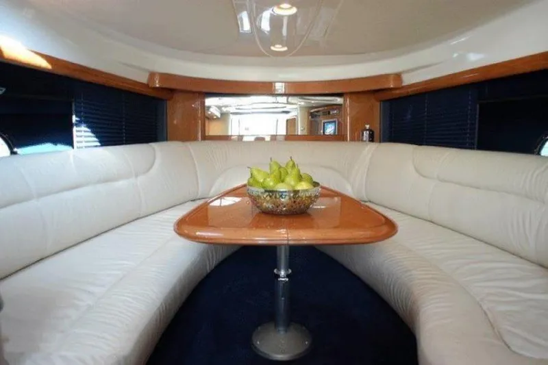 Slide: The Image of Interior of 2003 Cranchi Endurance 39 yacht with white seating and wooden table. - 7