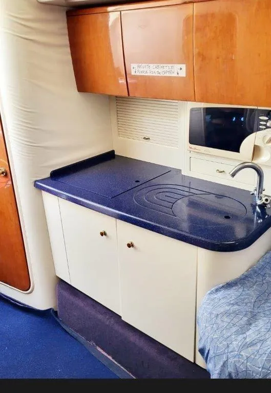 Slide: The Image of 2003 Cranchi Endurance 39 yacht interior kitchen with wooden cabinets and blue countertop. - 8