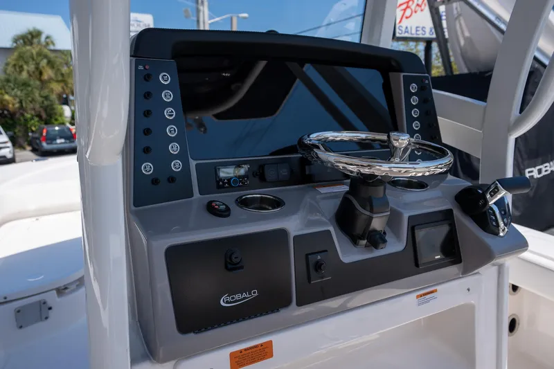 Slide: The Image of 2025 Robalo R246 CAYMAN boat dashboard with steering wheel and control panel. - 11