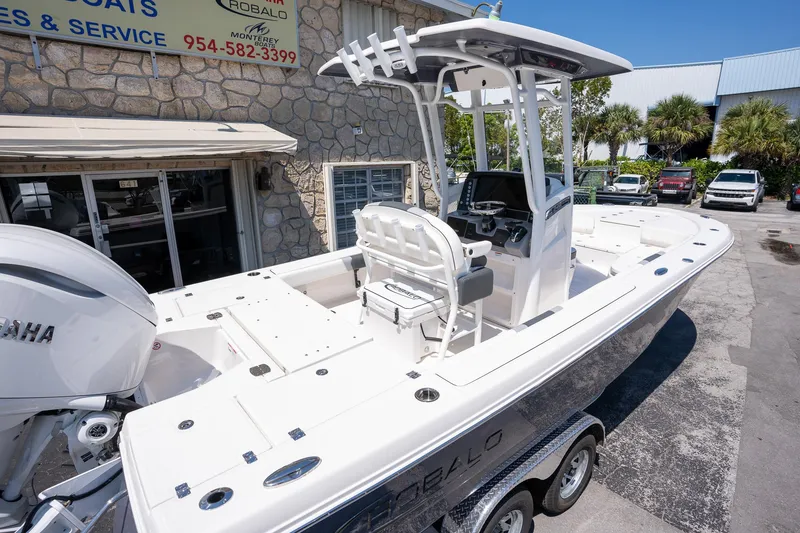 Slide: The Image of 2025 Robalo R246 CAYMAN boat on trailer, displayed outside dealership. - 4