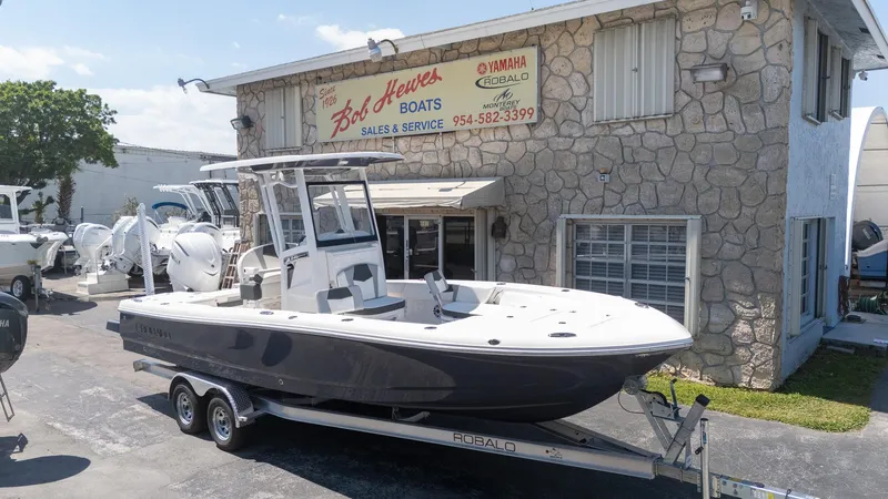 Slide: The Image of 2025 Robalo R246 CAYMAN boat on trailer outside Bob Hewes Boats dealership. - 5