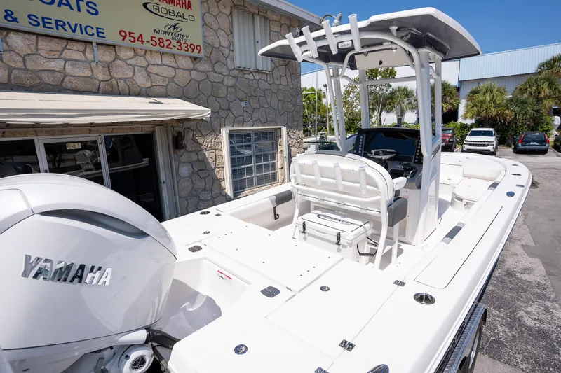 Slide: The Image of 2025 Robalo R246 CAYMAN boat with Yamaha engine, parked outside a service shop. - 7