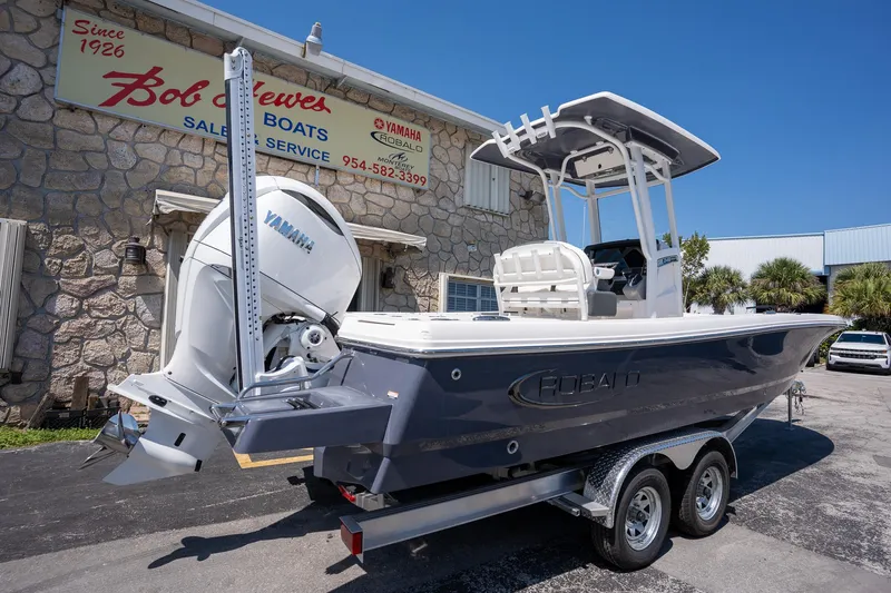 Slide: The Image of 2025 Robalo R246 CAYMAN boat with Yamaha engine, parked outside a dealership. - 8
