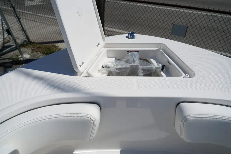 Slide: The Image of 2025 Robalo R200 boat bow storage compartment open, showing interior details. - 6