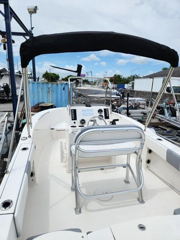 Slide: The Image of 2020 Robalo R180 boat interior with steering console and seating under a black canopy. - 7