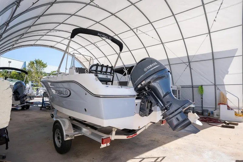 Slide: The Image of 2025 Robalo R180 boat with Yamaha engine in a covered storage area. - 15
