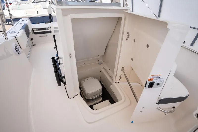 Slide: The Image of 2025 Robalo R180 boat interior with open storage compartment and portable toilet. - 6