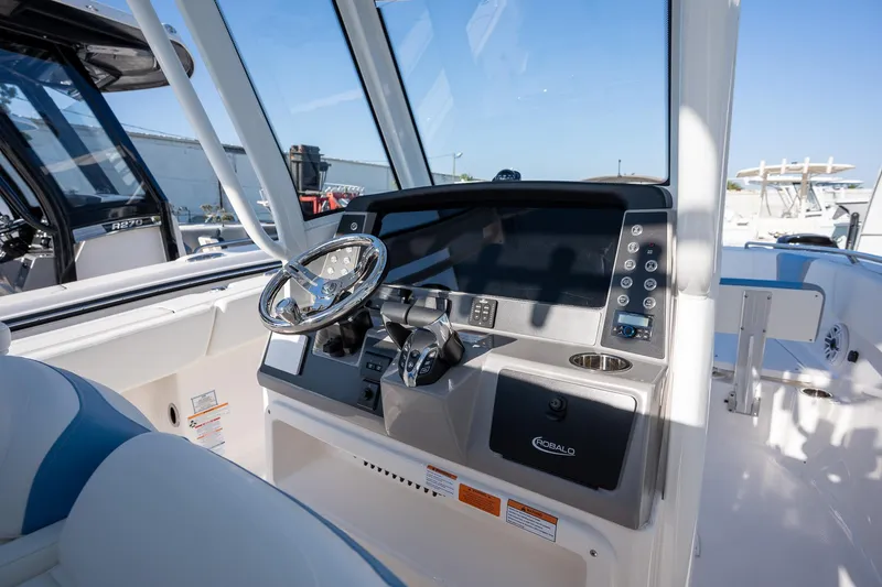 Slide: The Image of 2025 Robalo R270 boat cockpit with modern steering and control panel. - 12