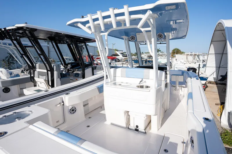 Slide: The Image of 2025 Robalo R270 boat with sleek design and modern features, docked under clear blue sky. - 14