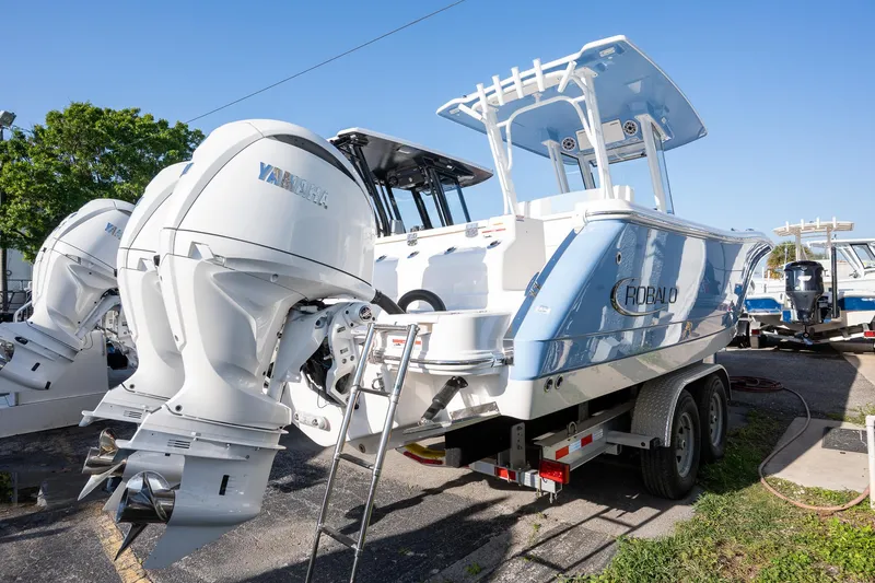 Slide: The Image of 2025 Robalo R270 boat with Yamaha engines on a trailer, parked outdoors. - 20