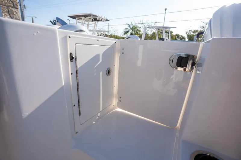 Slide: The Image of 2025 Robalo R270 boat storage compartment with sleek white finish and secure latch. - 16