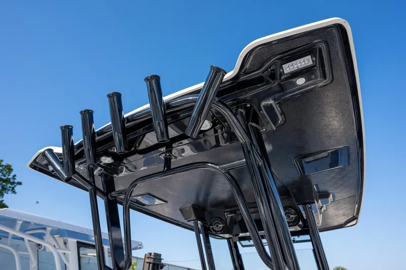 Slide: The Image of 2025 Robalo R270 boat T-top with rod holders against clear blue sky. - 7