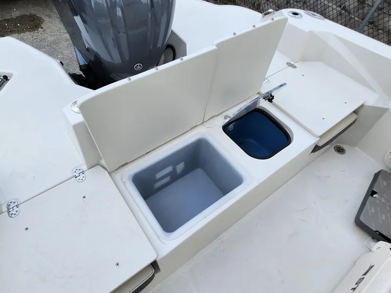 Slide: The Image of 2023 Stingray 236CC boat interior with storage compartments and engine view. - 12