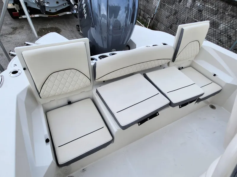 Slide: The Image of 2023 Stingray 236CC boat seating area with white cushioned seats and backrests. - 13