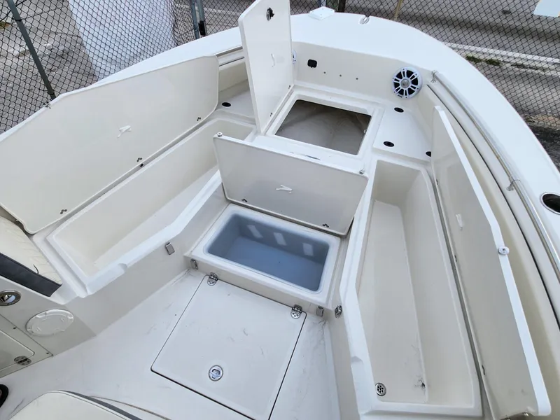 Slide: The Image of 2023 Stingray 236CC boat interior with open storage compartments and seating area. - 18
