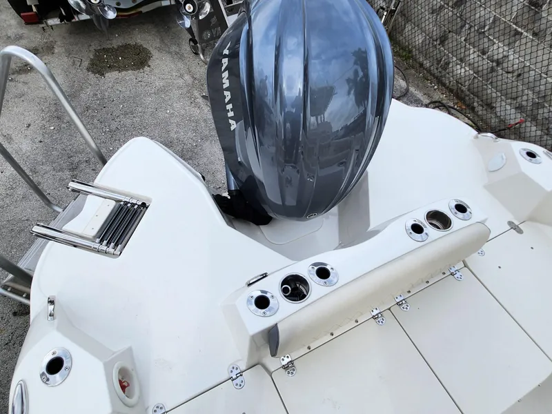 Slide: The Image of 2023 Stingray 236CC boat with Yamaha outboard motor, featuring rod holders and swim ladder. - 22