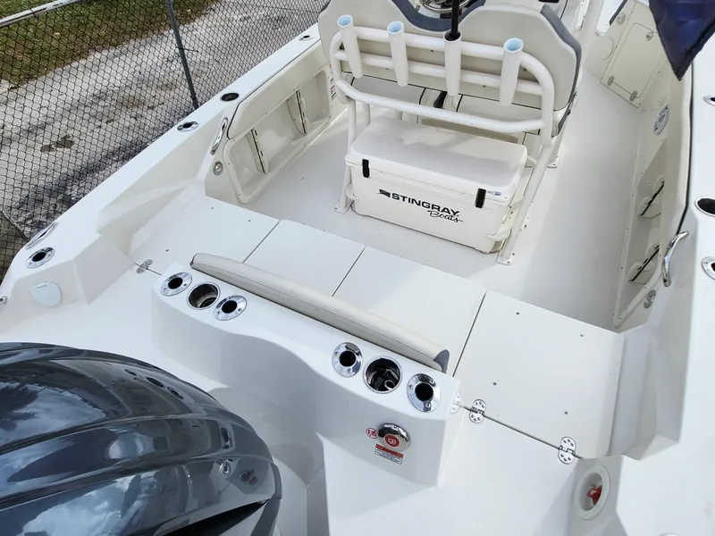 Slide: The Image of 2023 Stingray 236CC boat interior with seating, rod holders, and storage compartments. - 23