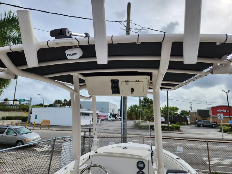 Slide: The Image of 2023 Stingray 236CC boat with T-top and Rigid lighting, parked near a street. - 26