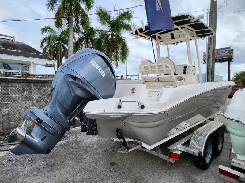 Slide: The Image of 2023 Stingray 236CC boat with Yamaha outboard motor, parked on a trailer, palm trees in background. - 27