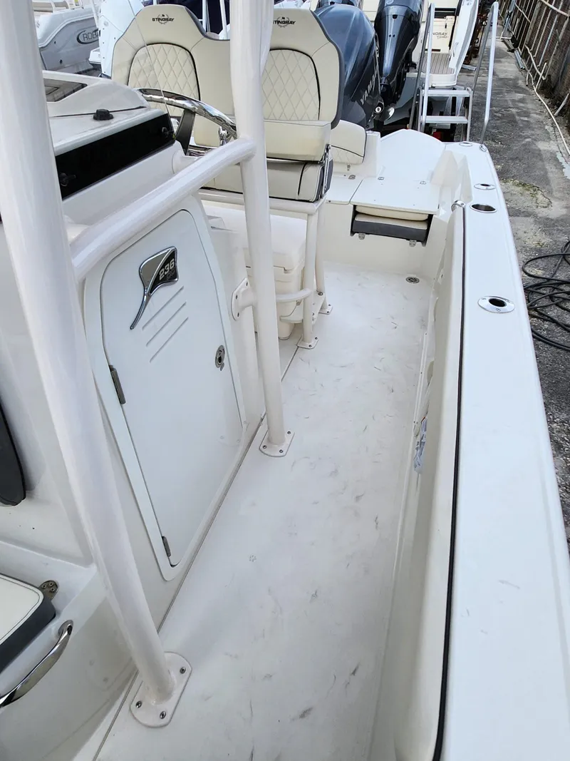 Slide: The Image of 2023 Stingray 236CC boat interior with white seating and storage compartments. - 7