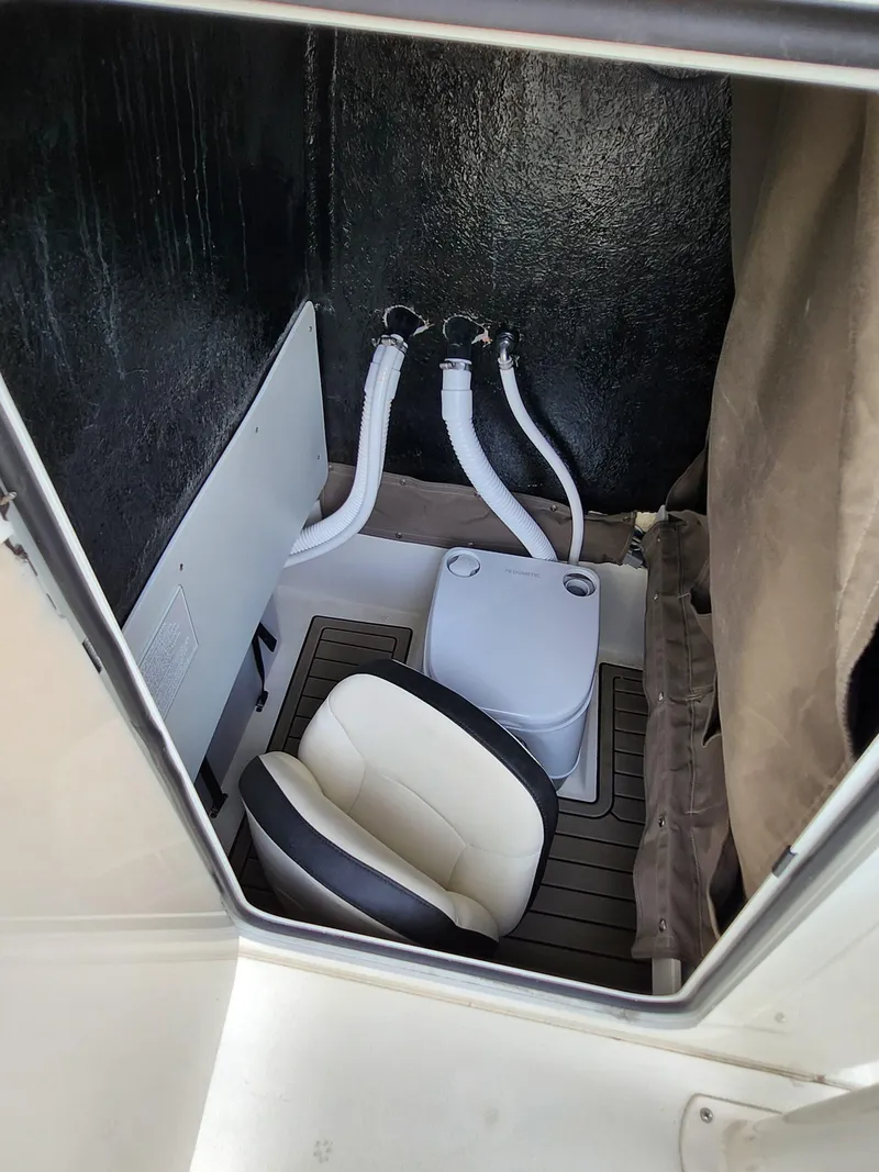 Slide: The Image of 2023 Stingray 236CC boat interior with seating and portable toilet. - 8