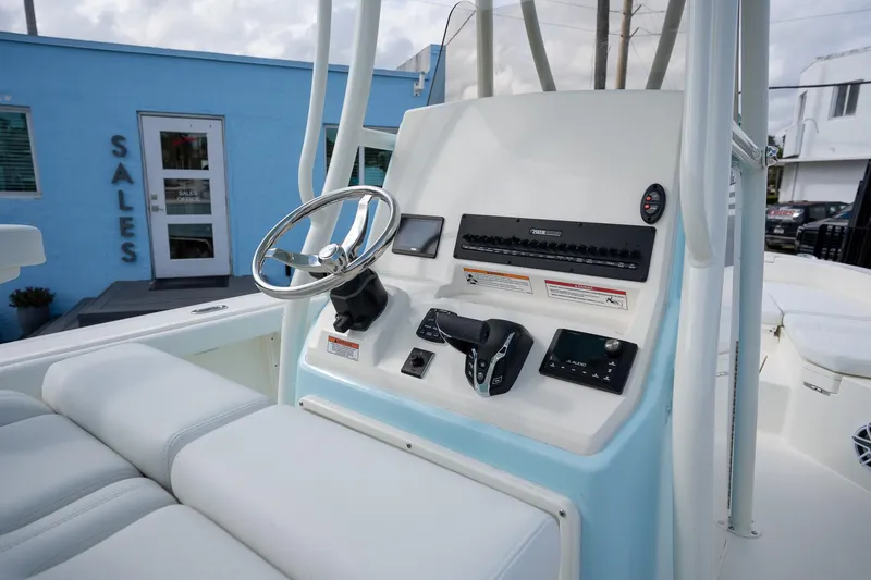 Slide: The Image of 2025 Pathfinder 2400 TRS boat console with steering wheel and controls, near sales office. - 12