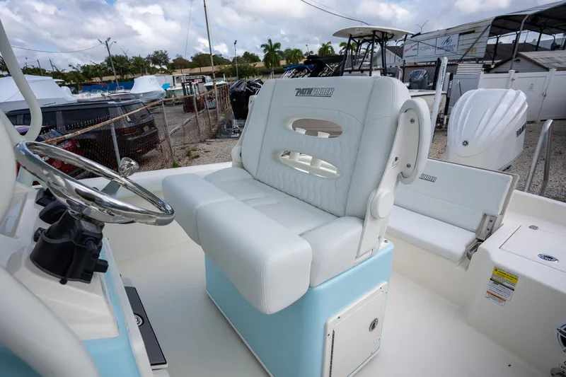 Slide: The Image of 2025 Pathfinder 2400 TRS boat interior with white seating and steering wheel. - 16