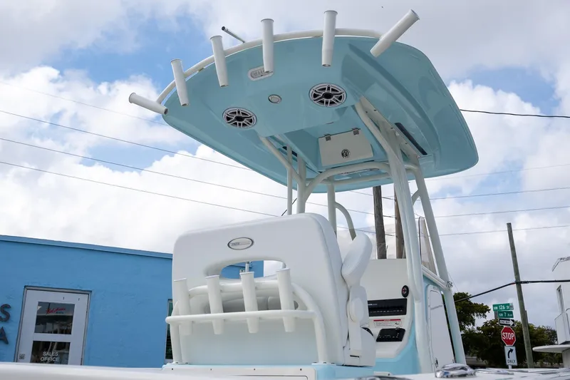 Slide: The Image of 2025 Pathfinder 2400 TRS boat with blue T-top and rod holders under cloudy sky. - 4