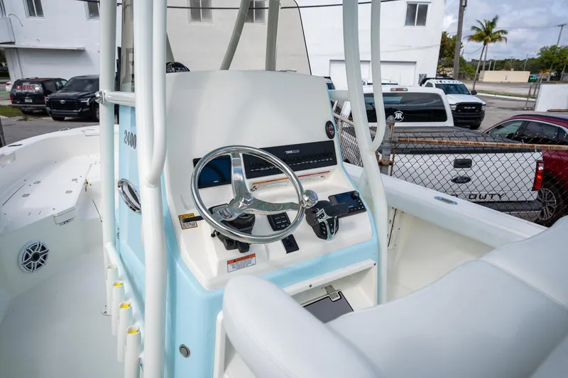 Slide: The Image of 2025 Pathfinder 2400 TRS boat console with steering wheel and controls, parked outdoors. - 7