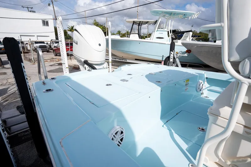 Slide: The Image of 2025 Pathfinder 2300 HPS boat, light blue deck, parked outdoors under a cloudy sky. - 8