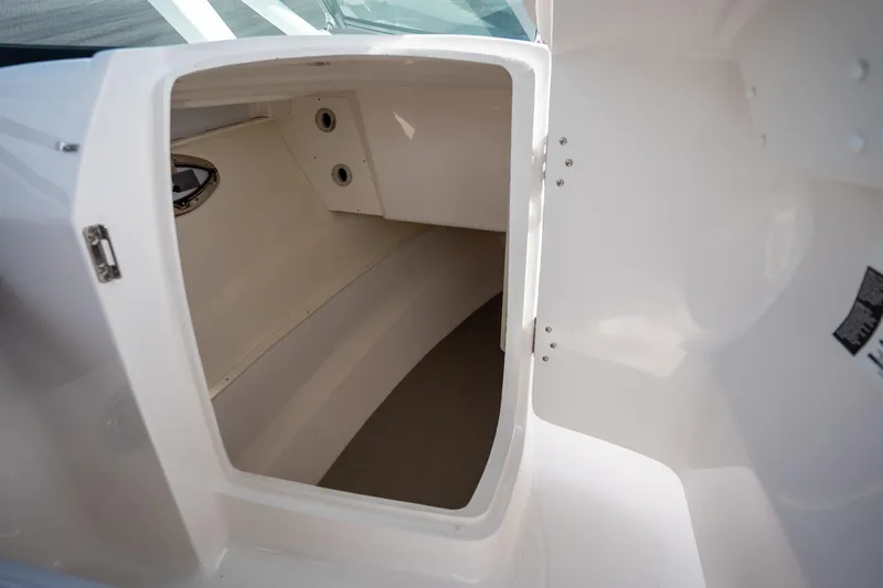Slide: The Image of 2025 Robalo R317 boat interior storage compartment, white finish, open door view. - 16
