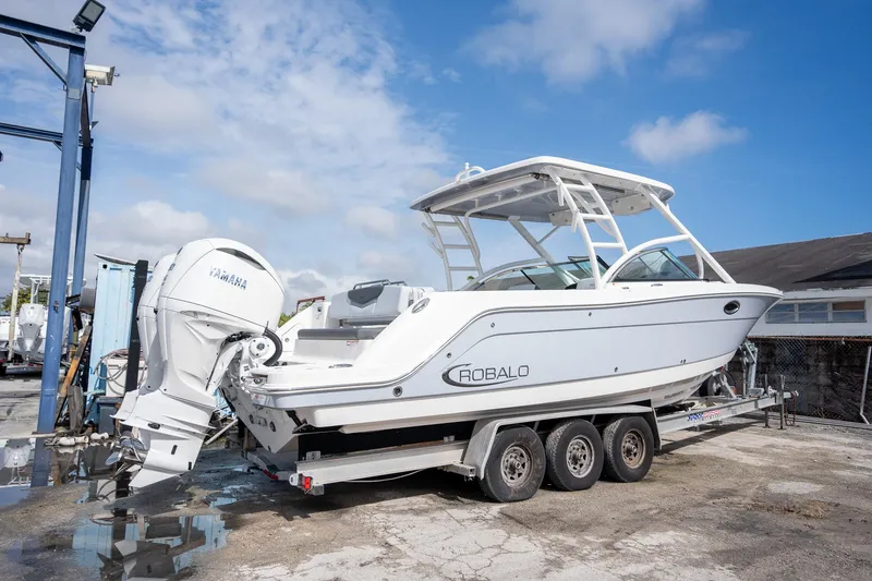 Slide: The Image of 2025 Robalo R317 boat on trailer, featuring Yamaha outboard motor, parked outdoors. - 20