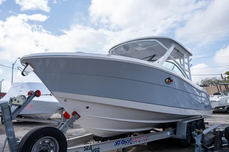 Slide: The Image of 2025 Robalo R317 boat on trailer under cloudy sky. - 22
