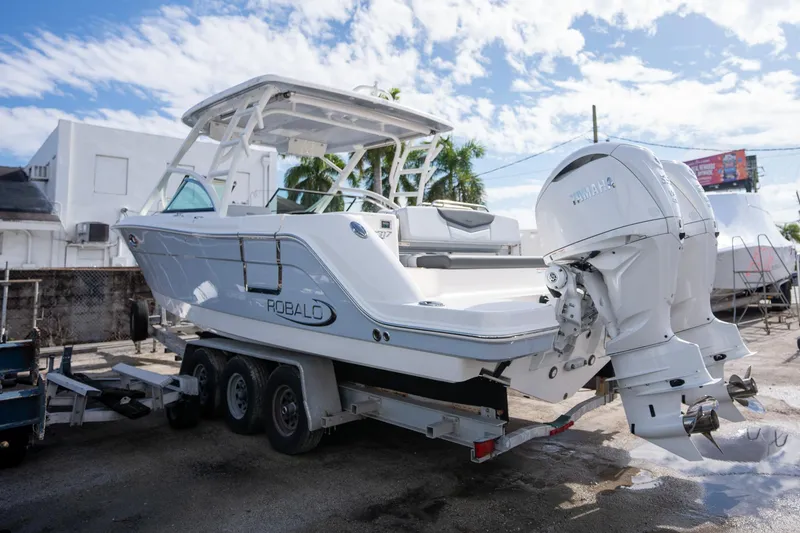 Slide: The Image of 2025 Robalo R317 boat on trailer, featuring dual Yamaha outboard engines. - 23