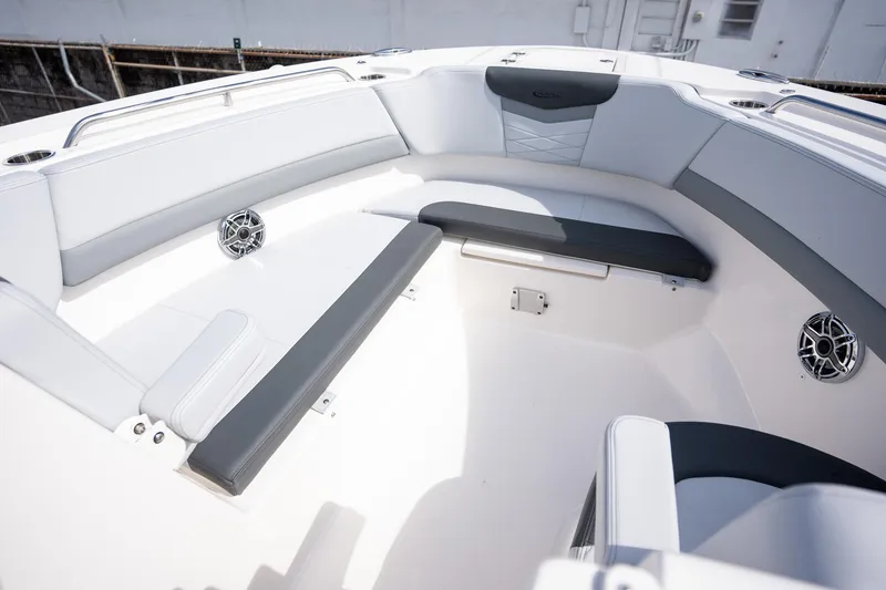 Slide: The Image of 2025 Robalo R317 boat interior with white and gray seating, cup holders, and speakers. - 9