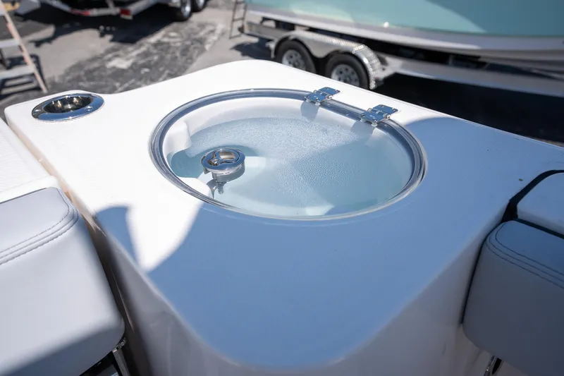 Slide: The Image of 2025 Robalo R230 boat livewell with a clear lid and cup holder. - 14