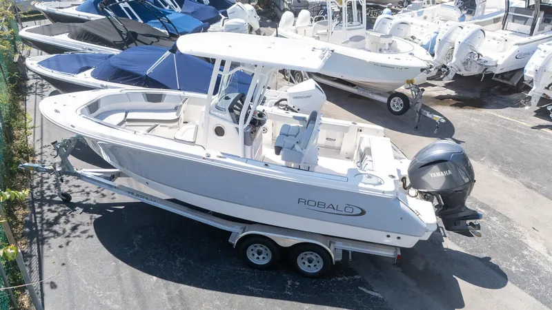 Slide: The Image of 2025 Robalo R230 boat on trailer, Yamaha engine, parked among other boats. - 4